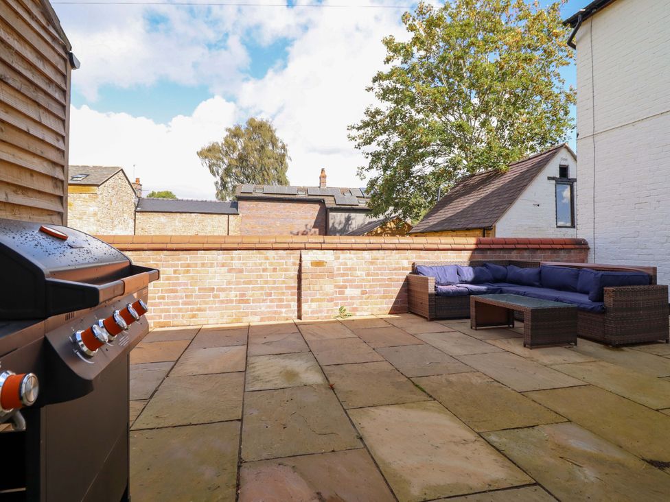 An outdoor patio with a grill and a sofa at The Farmhouse in Oswestry