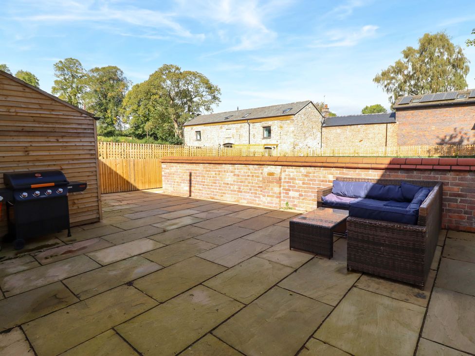 A garden with a patio and seating area at The Farmhouse in Oswestry