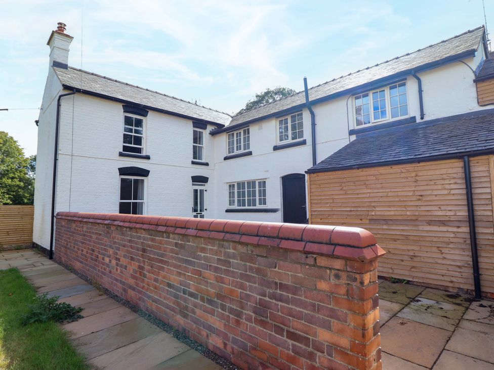 An outdoor view of a house with a brick wall at The Farmhouse in Oswestry
