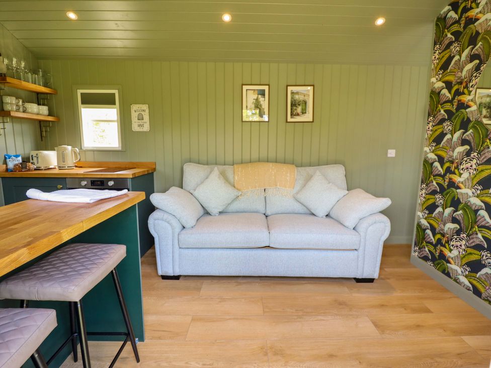 A living room with a sofa and bar counter at Bluebell in Grimsby