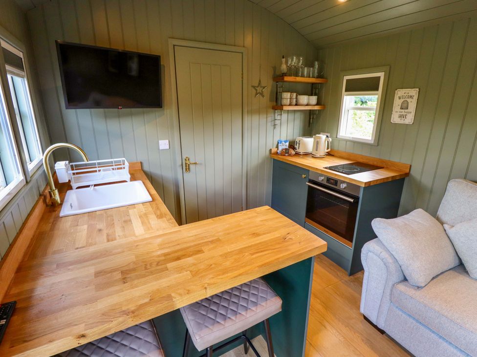 A kitchen with a sink, oven, and bar counter at Bluebell in Grimsby