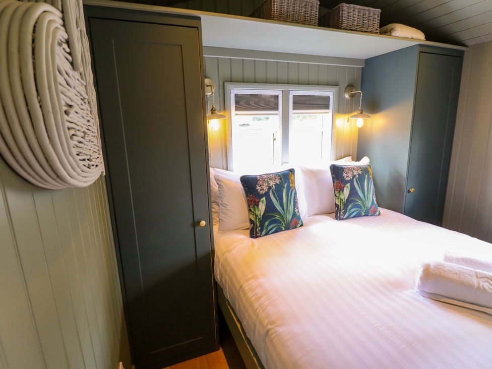 A bedroom with a bed and storage cabinets at Bluebell in Grimsby