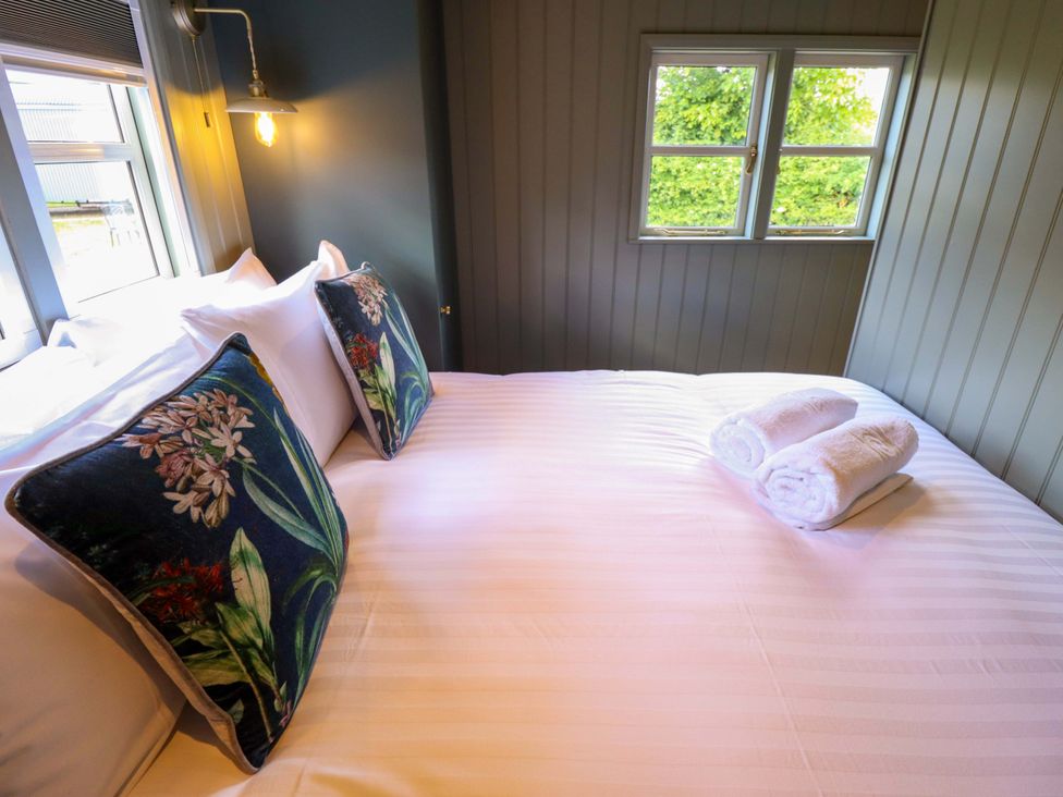 A bedroom with a bed, pillows, and towels at Bluebell in Grimsby
