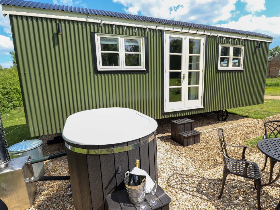 A tiny house with a hot tub and outdoor seating at Bluebell in Grimsby
