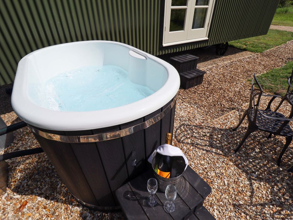 An outdoor area with a hot tub and champagne at Bluebell in Grimsby