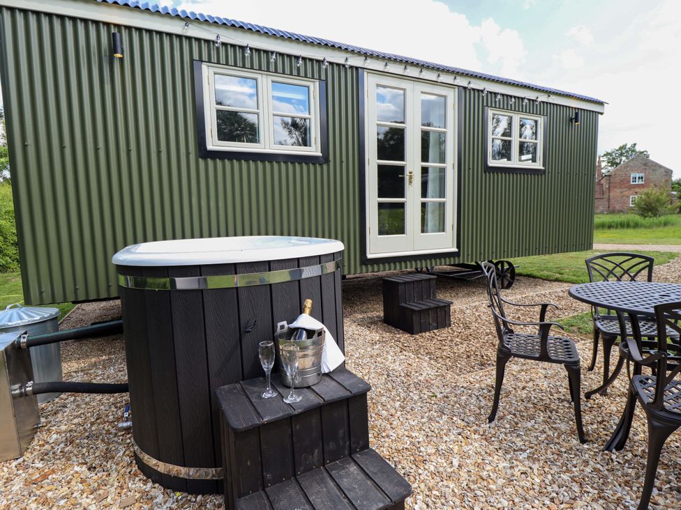 An outdoor area with a hot tub and seating table at Bluebell in Grimsby