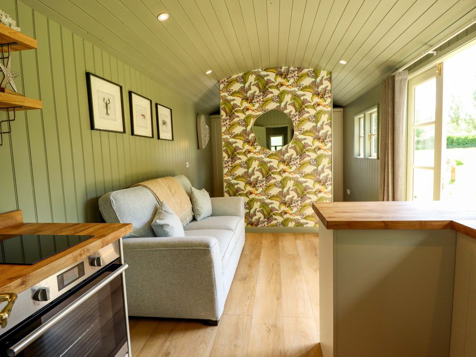A living room with a sofa and kitchen countertop at Primrose in Grimsby