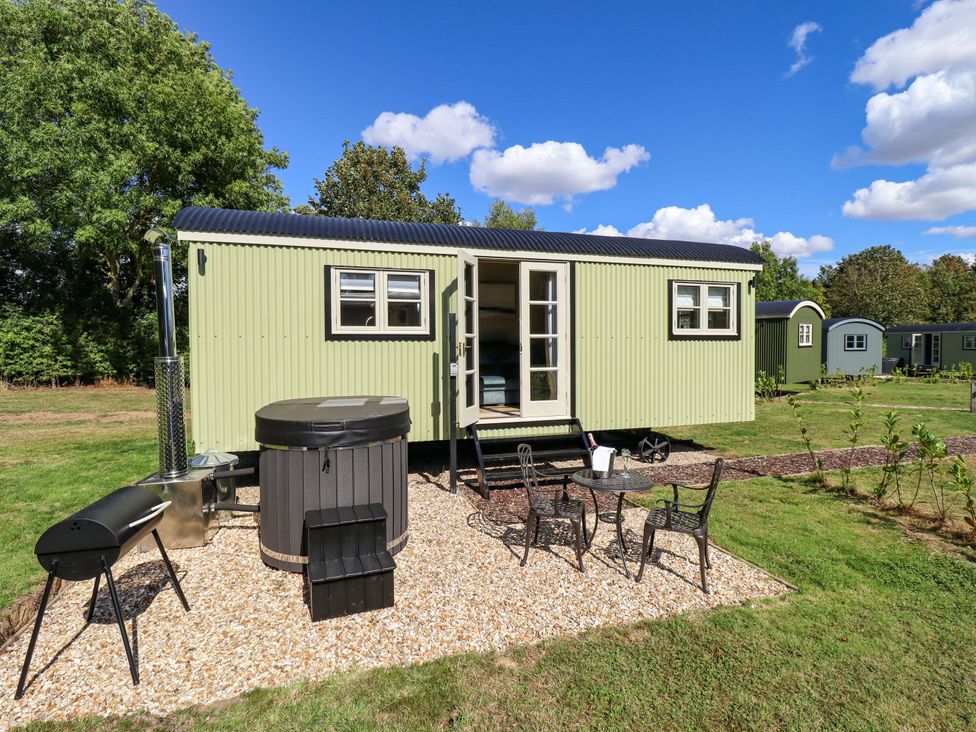 A tiny house with a hot tub and seating area at Magnolia in Grimsby