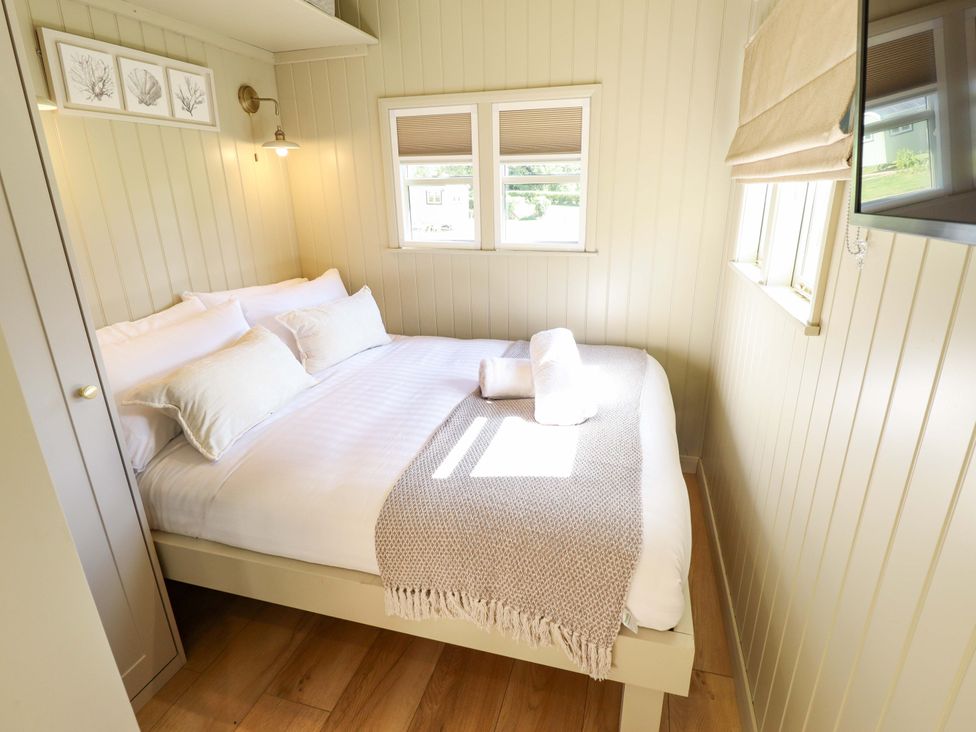 A bedroom with a bed and windows at Magnolia in Grimsby