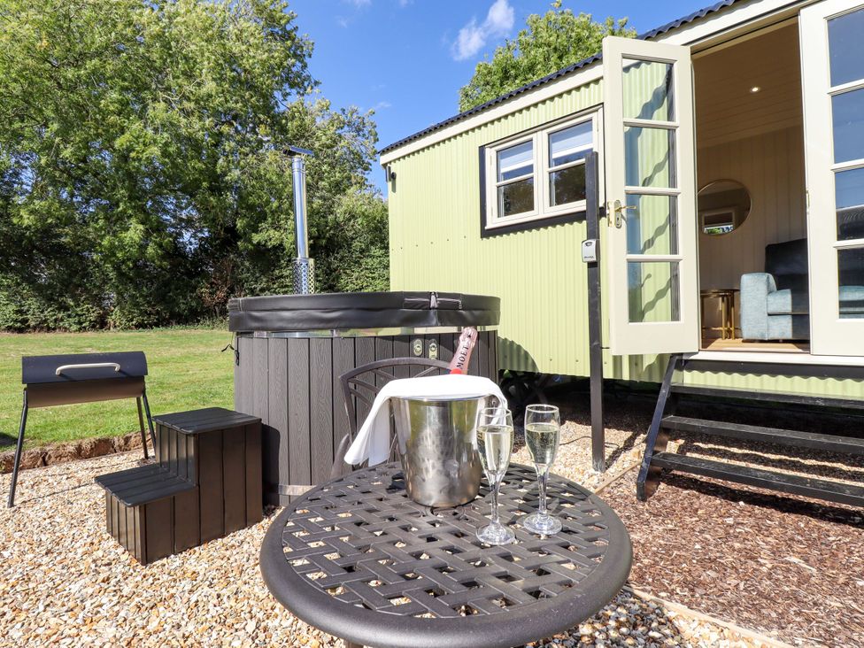An outdoor area with a hot tub, table and chairs at Magnolia in Grimsby