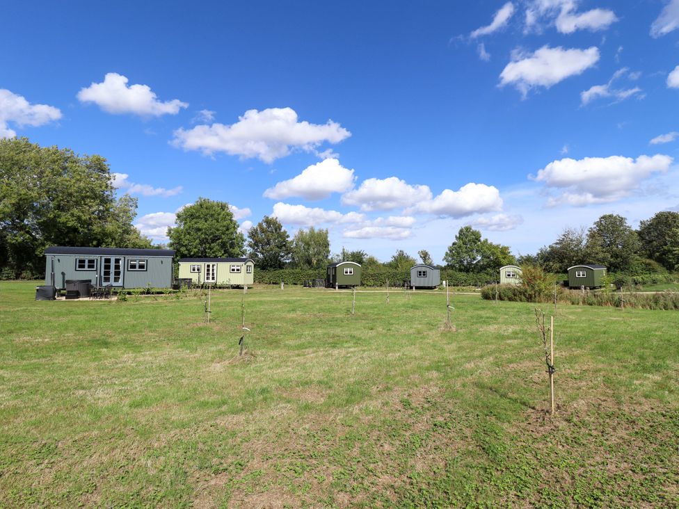 A view of shepherd's huts in a green field at Magnolia in Grimsby