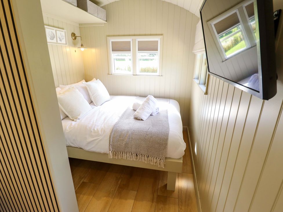 A bedroom with a bed and television at Snowdrop in Grimsby