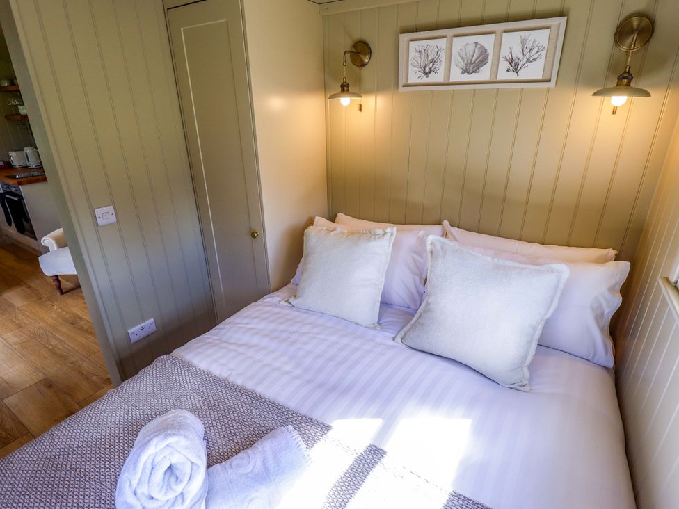 A bedroom with a bed and wall art at Snowdrop in Grimsby
