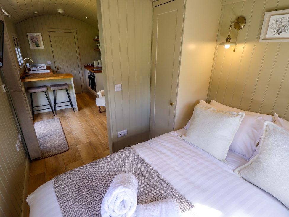 A bedroom with a bed and kitchen area at Snowdrop in Grimsby