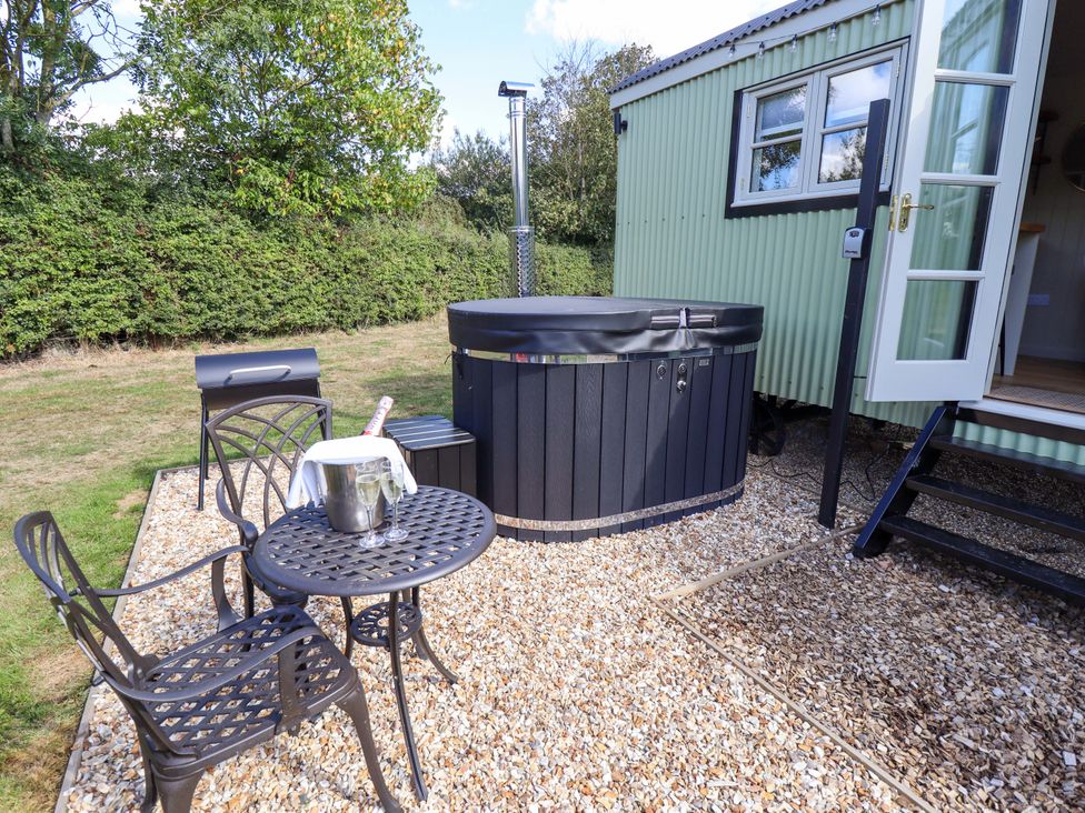 An outdoor area with a hot tub and seating at Snowdrop in Grimsby