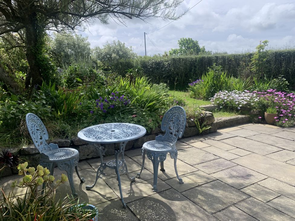 A garden with a table and chairs at Stargazy Skies in Beacon Drive near St Agnes