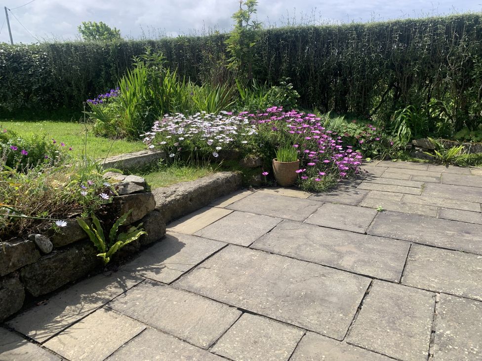 A garden with flowers and stone paving at Stargazy Skies near Beacon Drive St Agnes