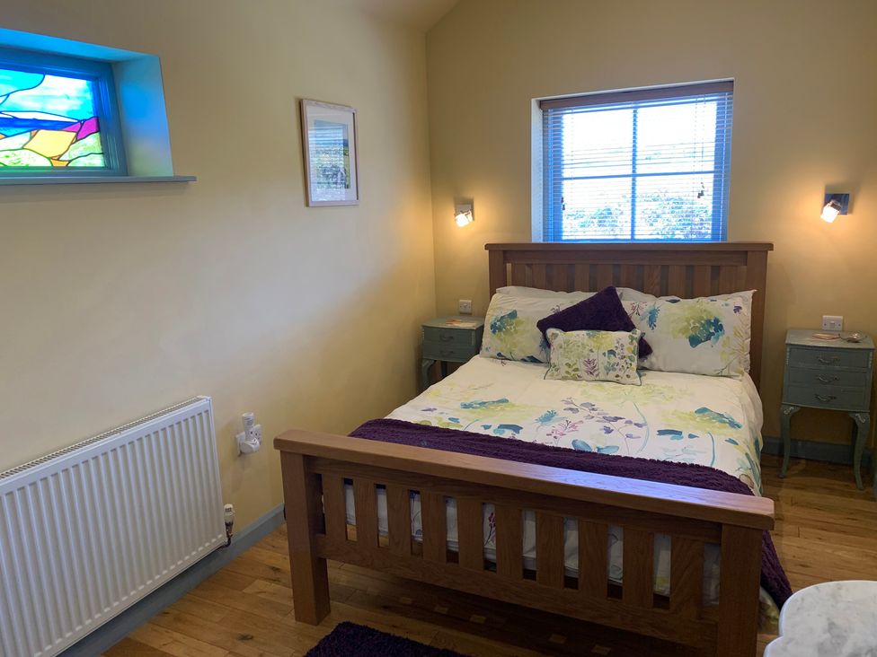 A bedroom with a bed and bedside tables at Stargazy Skies in Beacon Drive near St Agnes