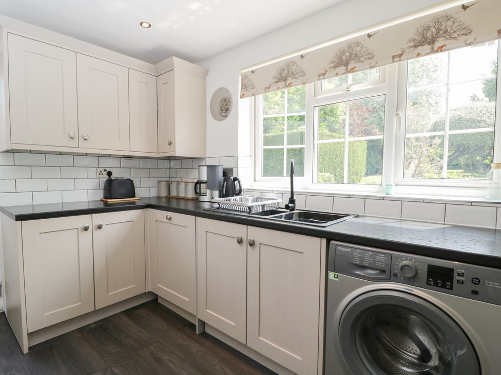 A kitchen with cabinets, sink, toaster, kettle and washing machine at Lorien in Fifield