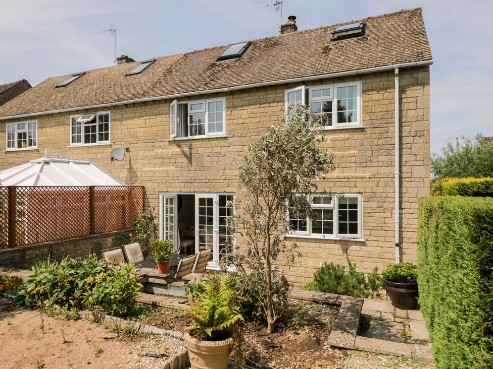 A garden with a house, seating area, and plants at Lorien in Fifield