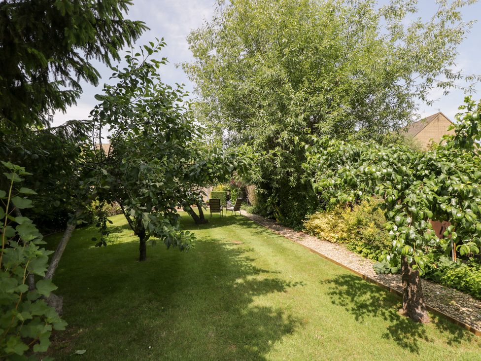 A garden with trees and seating area at Lorien in Fifield