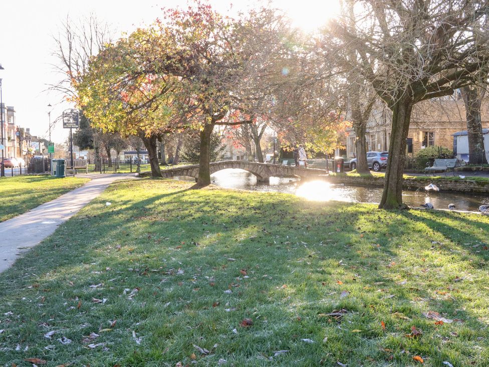 A park with a bridge over a river at Lorien in Bourton-On-The-Water