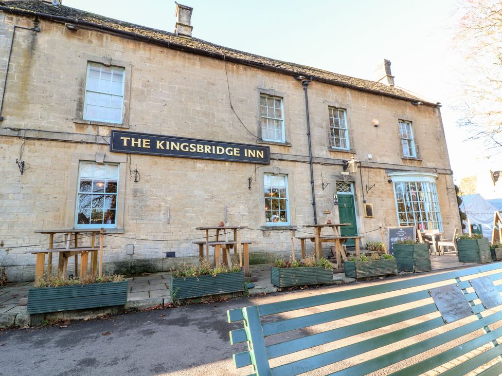 Exterior view of The Kingsbridge Inn with tables and planters in Bourton-On-The-Water