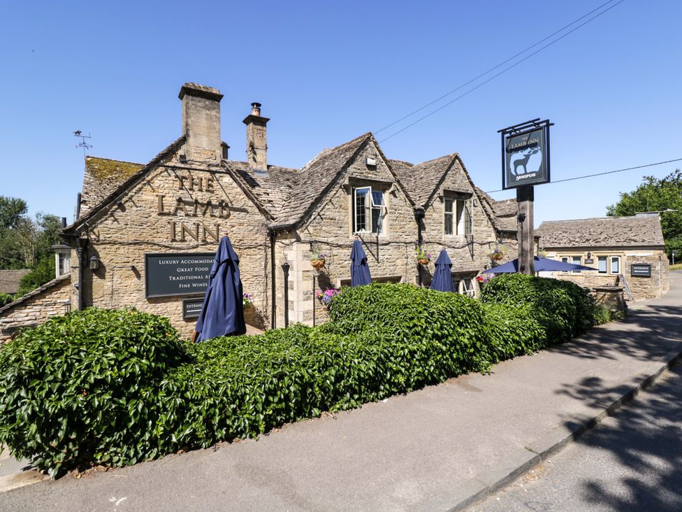 A building exterior with a sign for The Lamb Inn in Bourton-On-The-Water