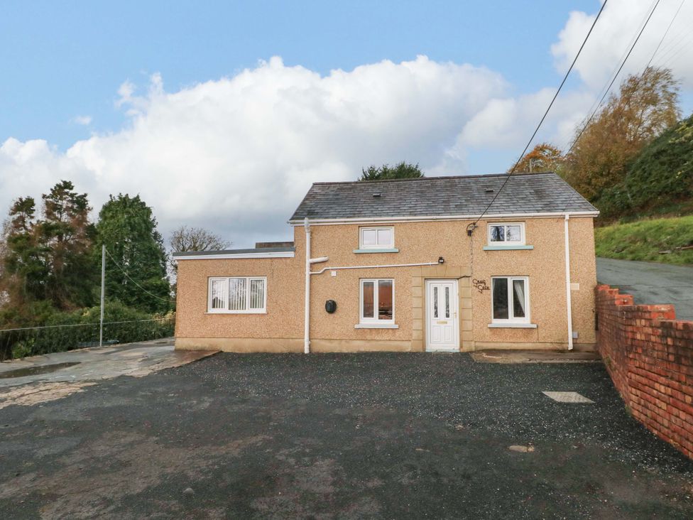 A house with a pathway and trees at Graig Goch in Burry Port
