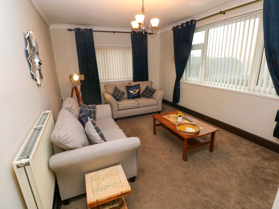 A living room with a sofa and coffee table at Graig Goch in Burry Port