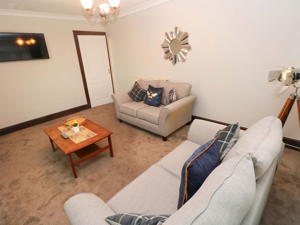 A living room with a sofa and coffee table at Graig Goch in Burry Port