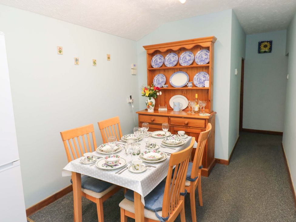 A dining room with a table set for a meal at Graig Goch in Burry Port