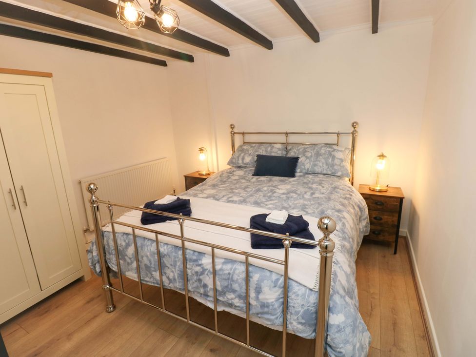 A bedroom with a bed and wardrobe at Graig Goch in Burry Port