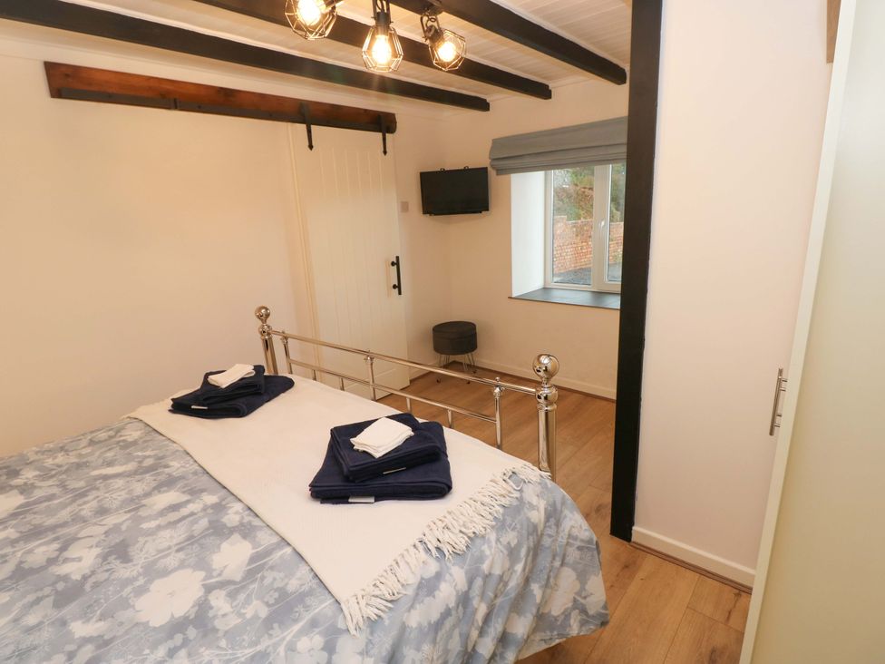 A bedroom with a bed and television at Graig Goch in Burry Port