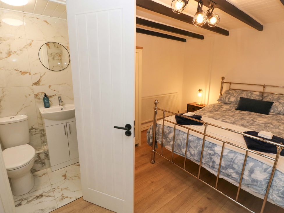 A bedroom with a bed and a bathroom at Graig Goch in Burry Port