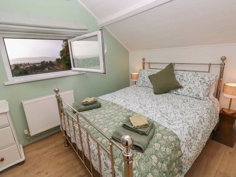 A bedroom with a bed and window view at Graig Goch Burry Port