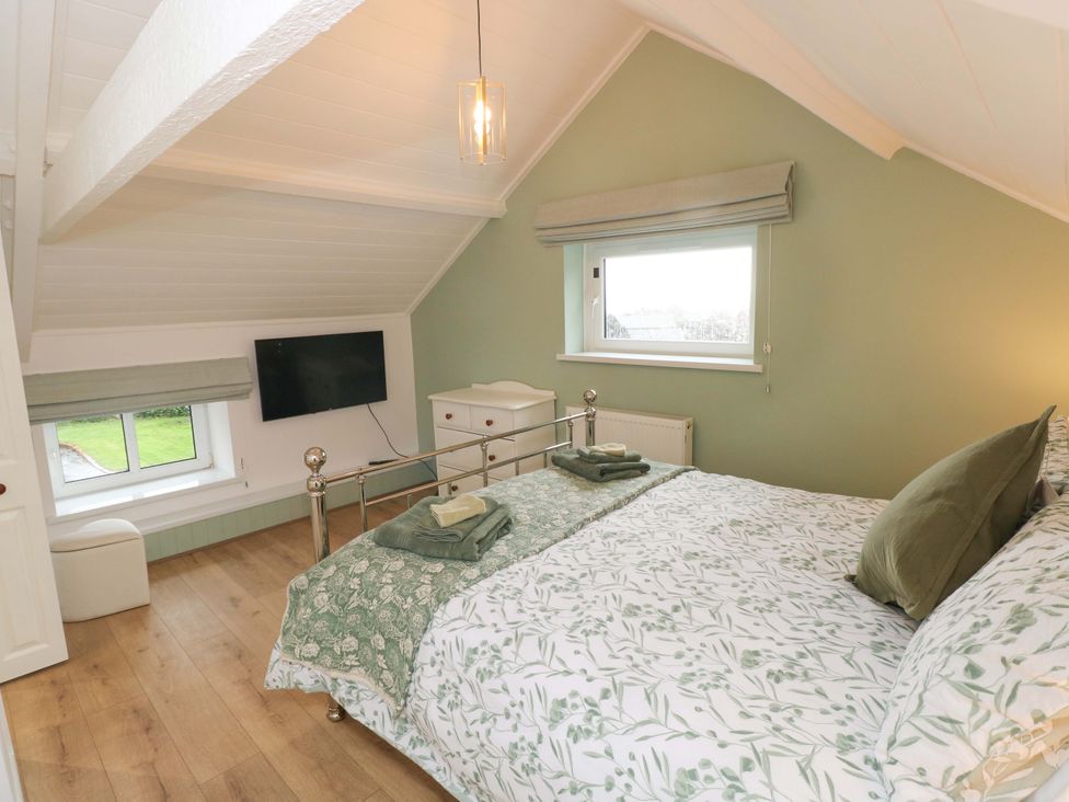 A bedroom with a bed and television at Graig Goch in Burry Port