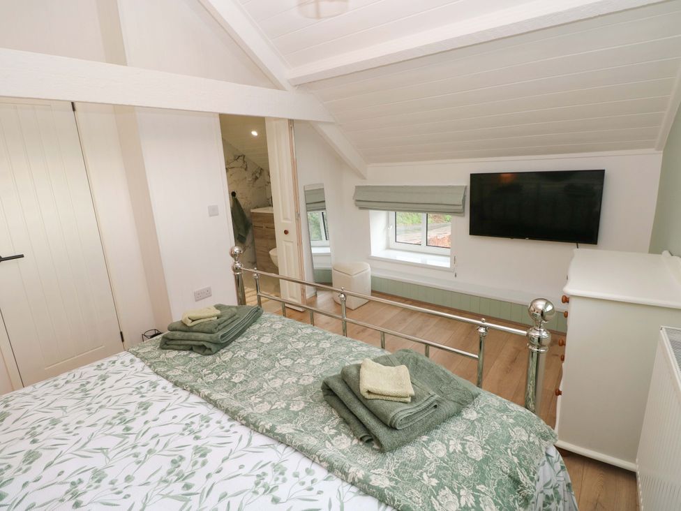 A bedroom with a bed and television at Graig Goch in Burry Port