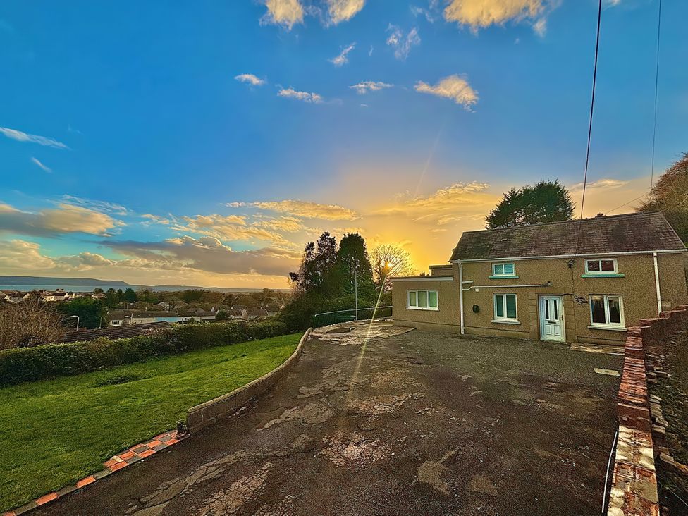 A house with a driveway and grass at Graig Goch in Burry Port
