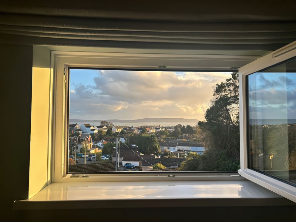 A view from a window showing houses and trees at Graig Goch Burry Port