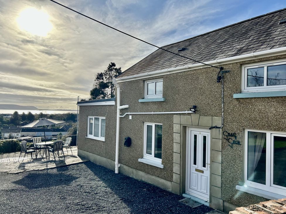 An outdoor area with a house and seating at Graig Goch in Burry Port