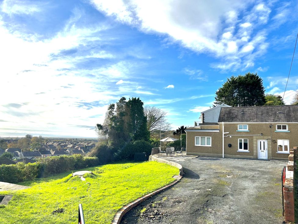 A house with a driveway and grass area at Graig Goch in Burry Port