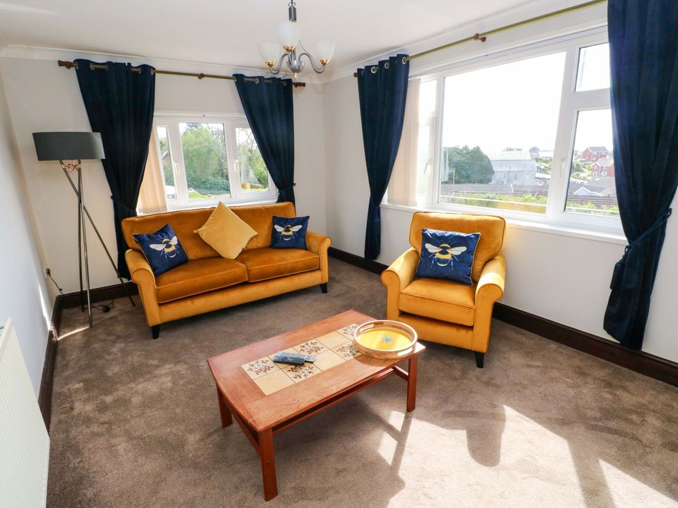 A living room with furniture and windows at Graig Goch in Burry Port
