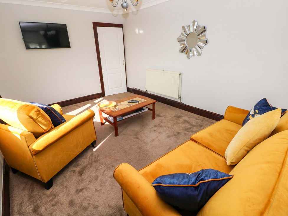 A living room with a sofa and coffee table at Graig Goch in Burry Port