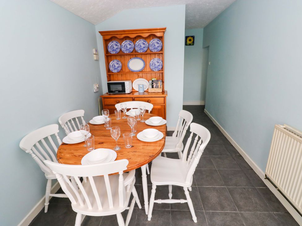 A dining room with a table and chairs at Graig Goch in Burry Port