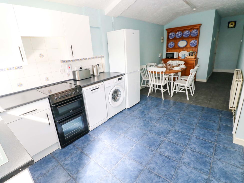A kitchen with appliances and dining area at Graig Goch in Burry Port