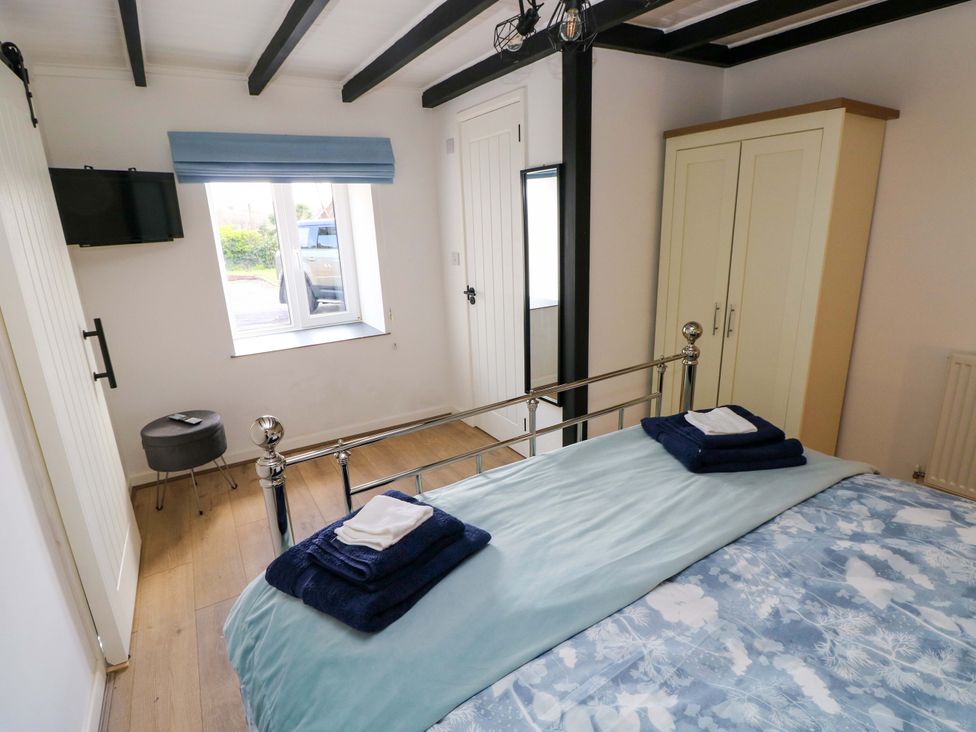 A bedroom with a bed and towels at Graig Goch in Burry Port