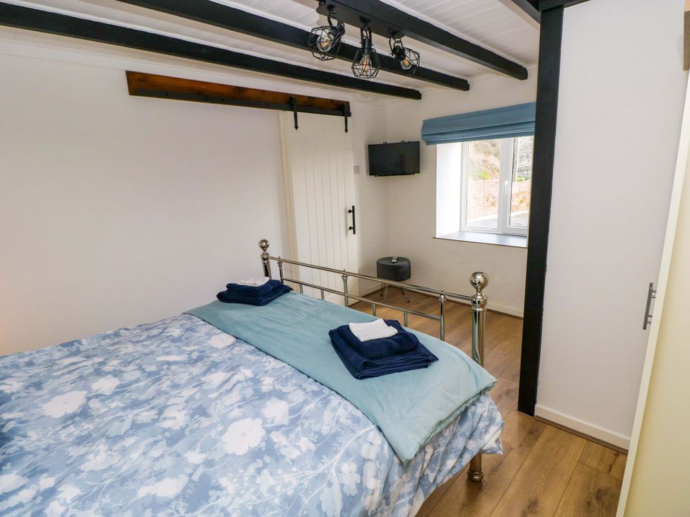 A bedroom with a bed and television at Graig Goch in Burry Port