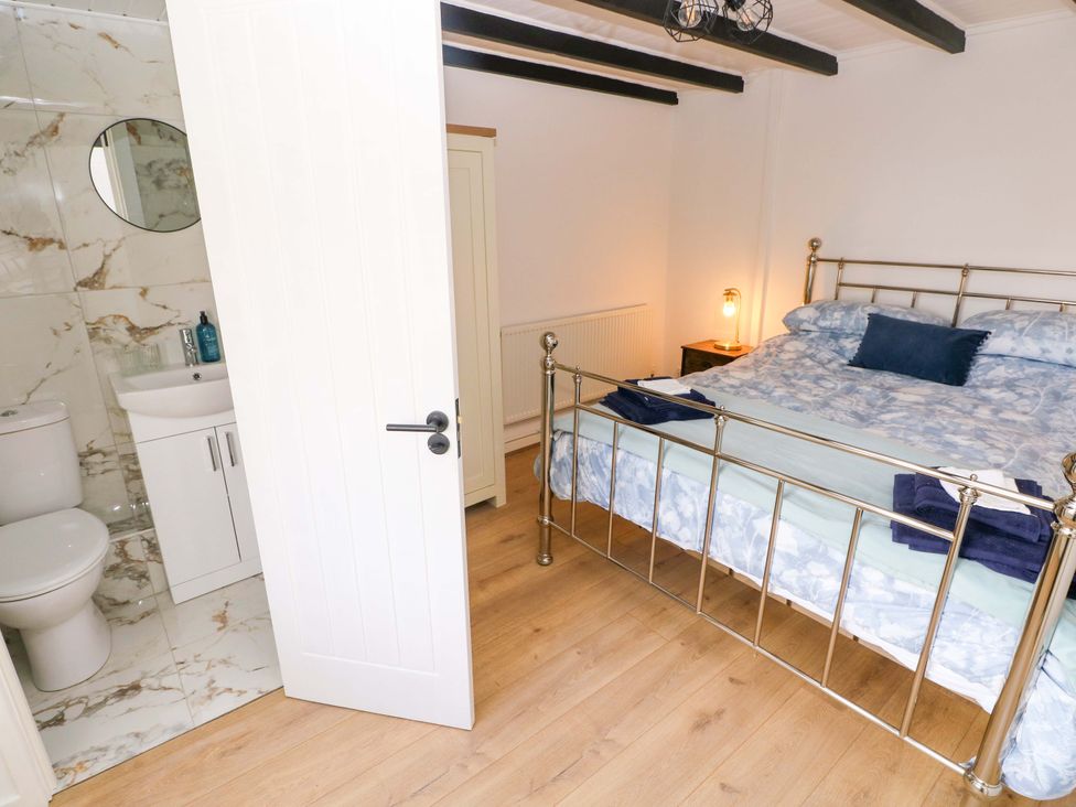 A bedroom with a bed and an en-suite bathroom at Graig Goch in Burry Port