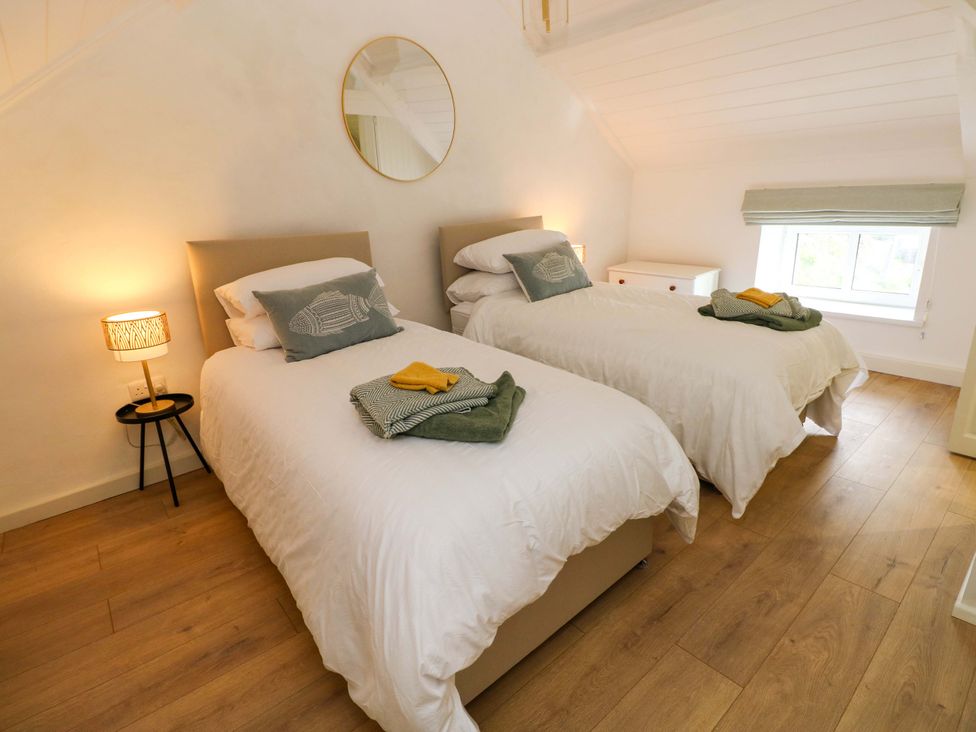 A bedroom with two single beds and a lamp at Graig Goch in Burry Port